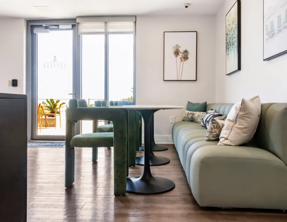 Rooftop resident lounge with built-in banquette seating, café tables, and access to an outdoor terrace.